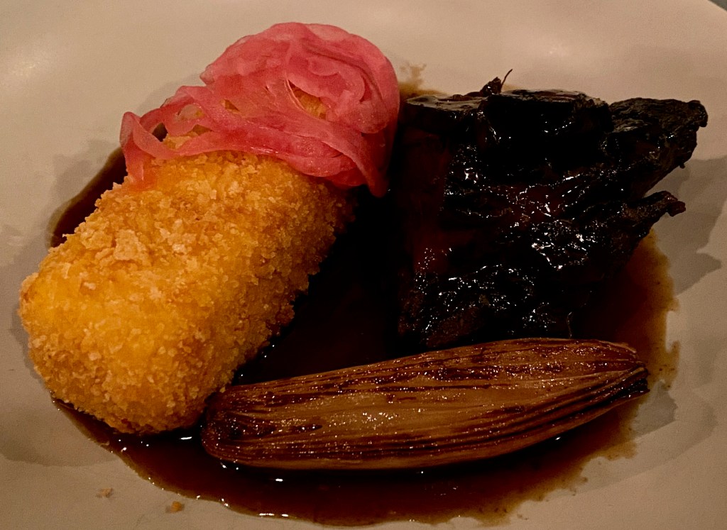 Golden crispy polenta cake with beef and charred shallot