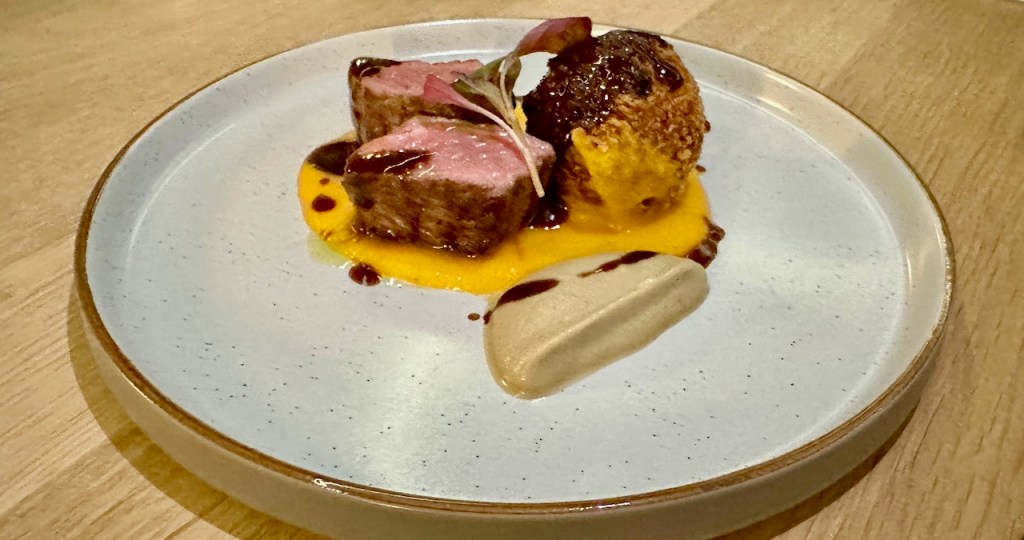 Golden lamb croquette and lamb cutlet with butternut squash puree on plate